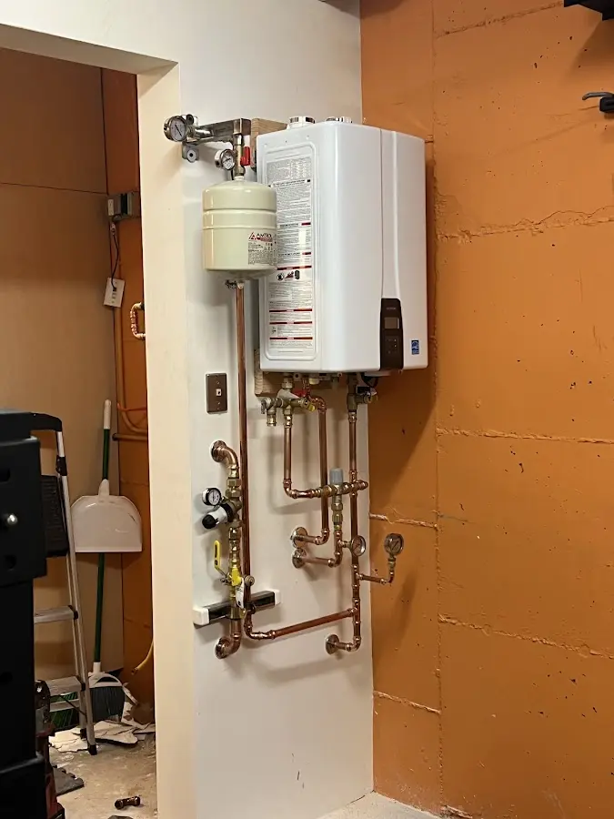 Plumbing technician inspecting water heater connections in Imlay City